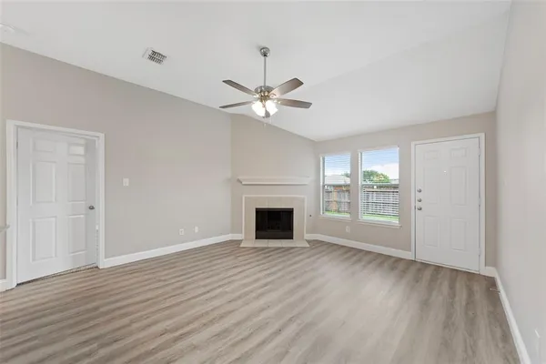 wooden floor fireplace and windows in an empty room