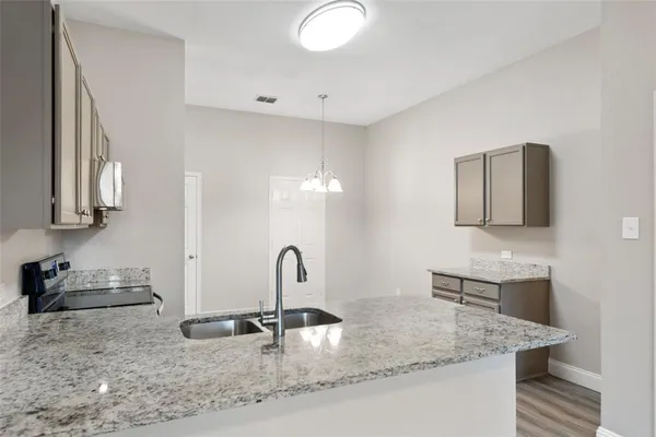 a large kitchen with a center island wooden floor stainless steel appliances and cabinets