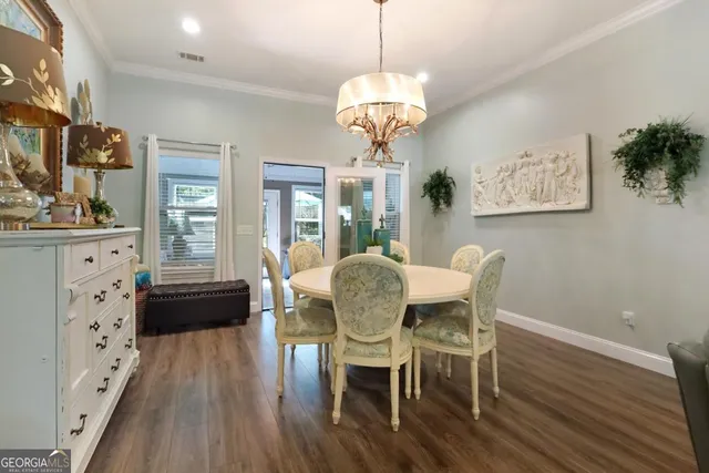 a view of a dining room with furniture a chandelier and wooden floor