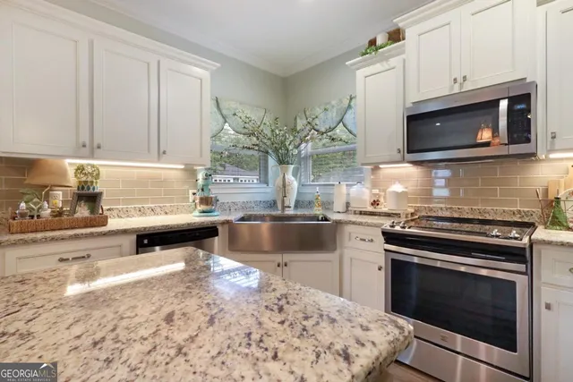 a kitchen with granite countertop a stove microwave and sink