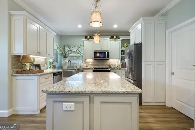 a kitchen with granite countertop a center island and stainless steel appliances