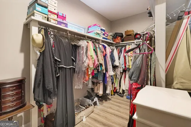 a view of walk in closet with clothes and shoes