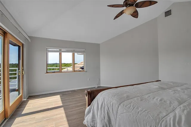 an empty room with windows and chandelier fan