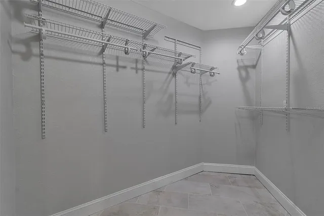 an empty room with ceiling fan and windows