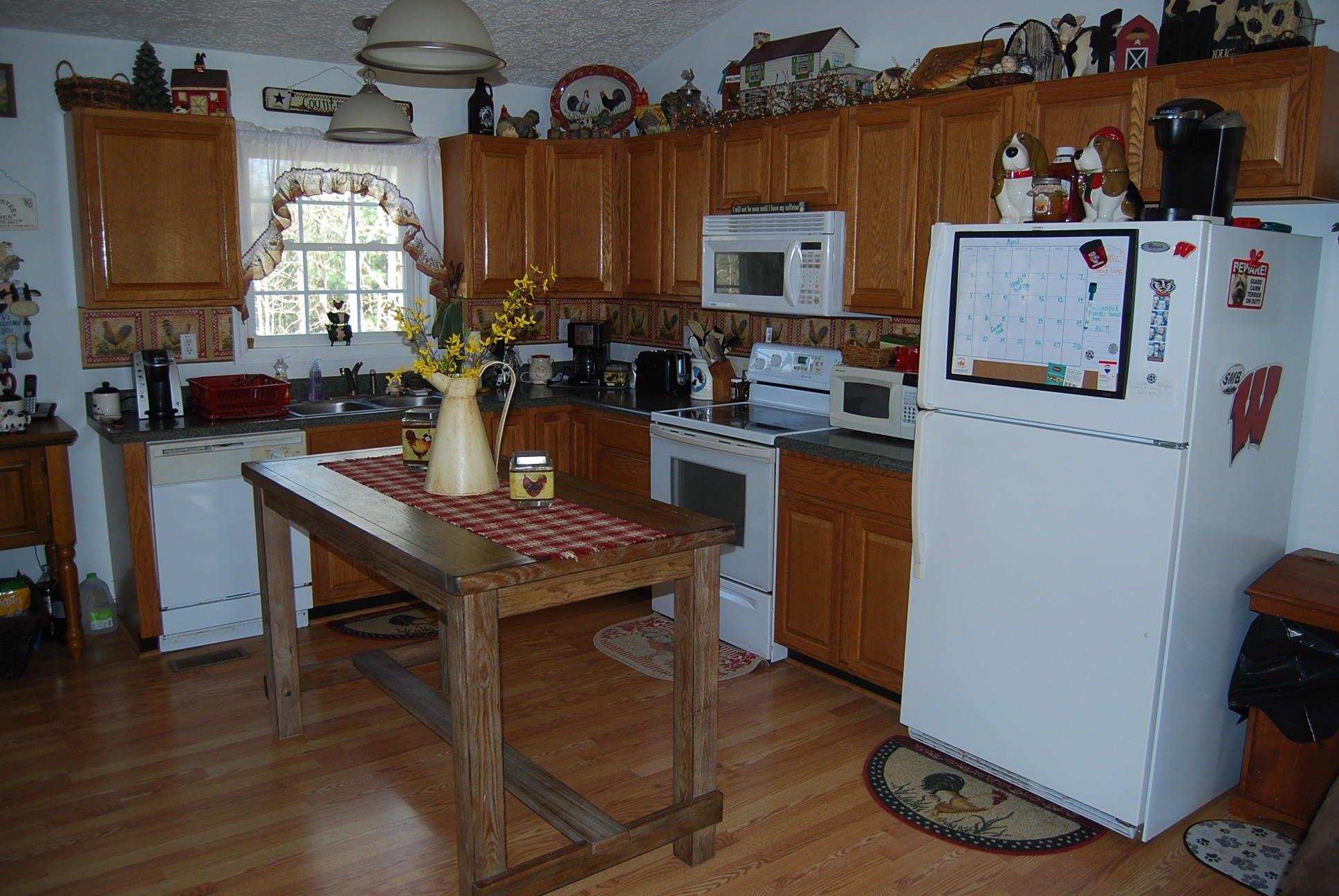 736 Holland Road Callaway, VA 24067 - Photo 10 of 45 a kitchen with a refrigerator a stove a sink dishwasher and a dining table with wooden floor
