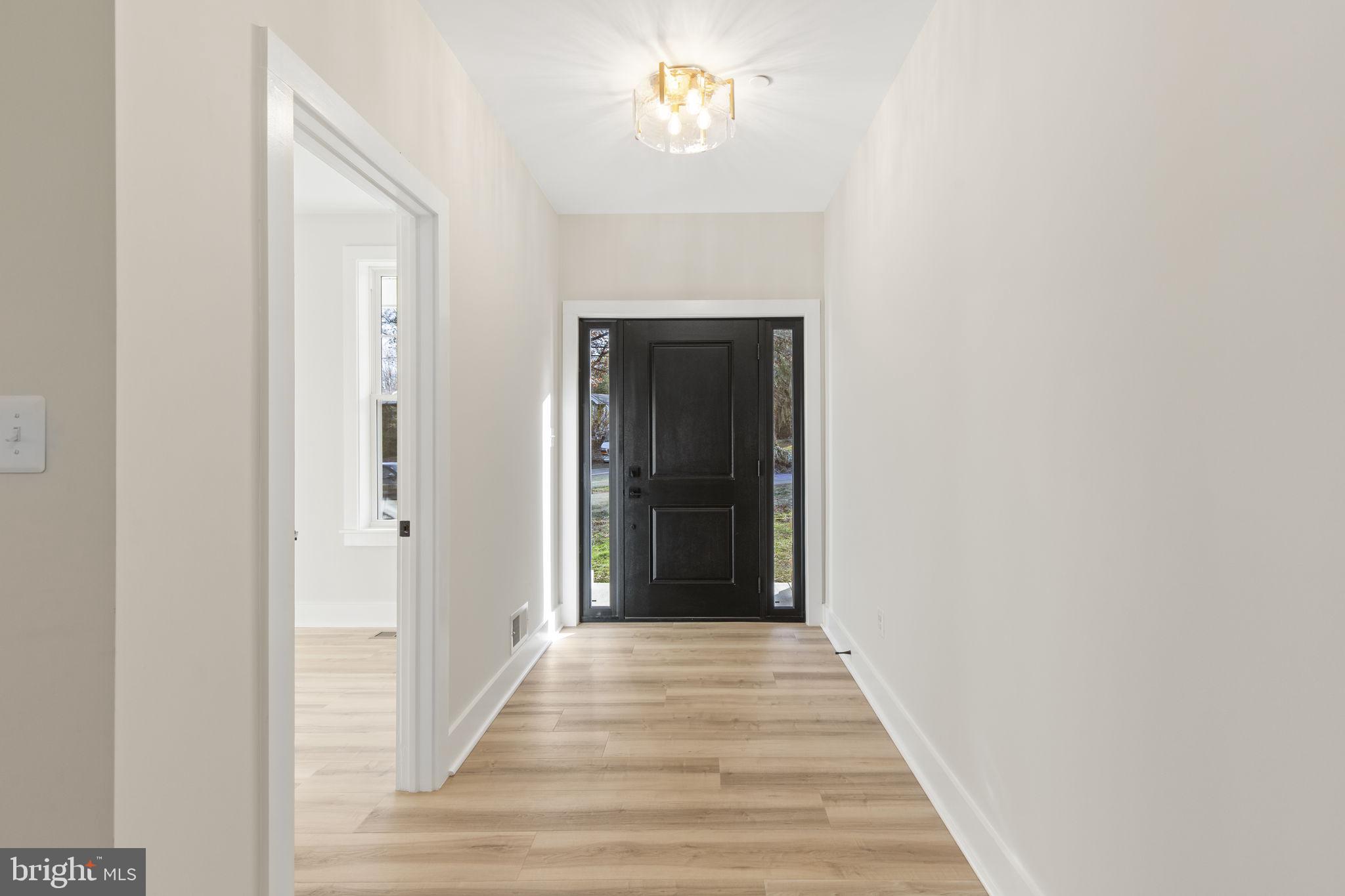 1108 Litchfield Road Baltimore, MD 21239 - Photo 15 of 109 a view of a hallway with wooden floor and a chandelier