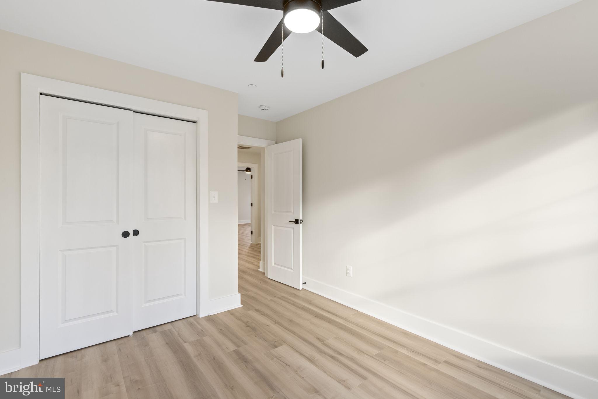 1108 Litchfield Road Baltimore, MD 21239 - Photo 34 of 109 a view of empty room with wooden floor and ceiling fan