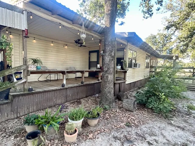 a front view of a house with plants and seating space