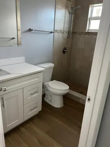 a bathroom with a granite countertop toilet and a sink