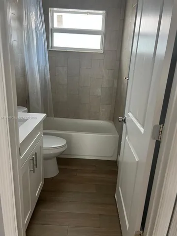 a bathroom with a sink a toilet a tub and shower