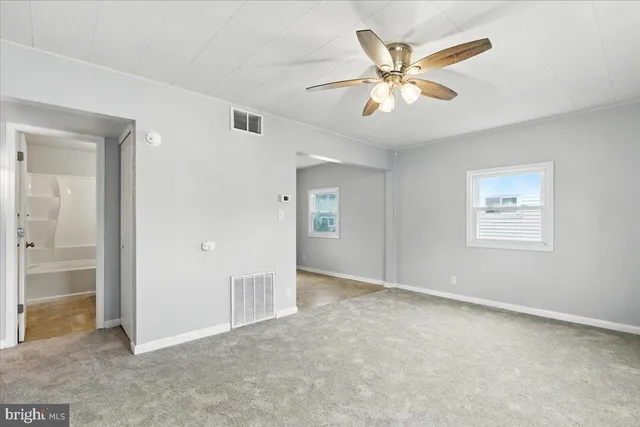 an empty room with closet and ceiling fan