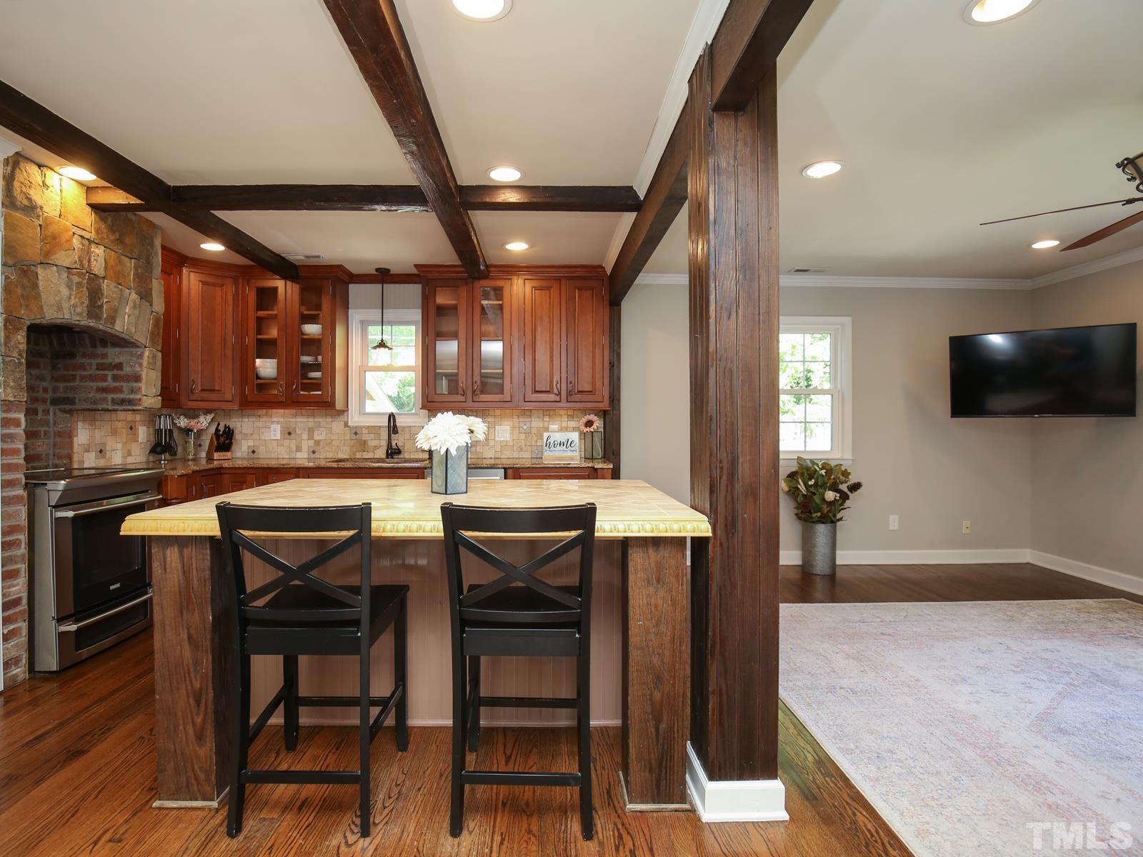 6013 Trinity Drive Raleigh, NC 27607 - Photo 8 of 30 a kitchen with stainless steel appliances granite countertop table chairs sink and cabinets