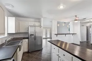 a kitchen with stainless steel appliances granite countertop a sink refrigerator and cabinets