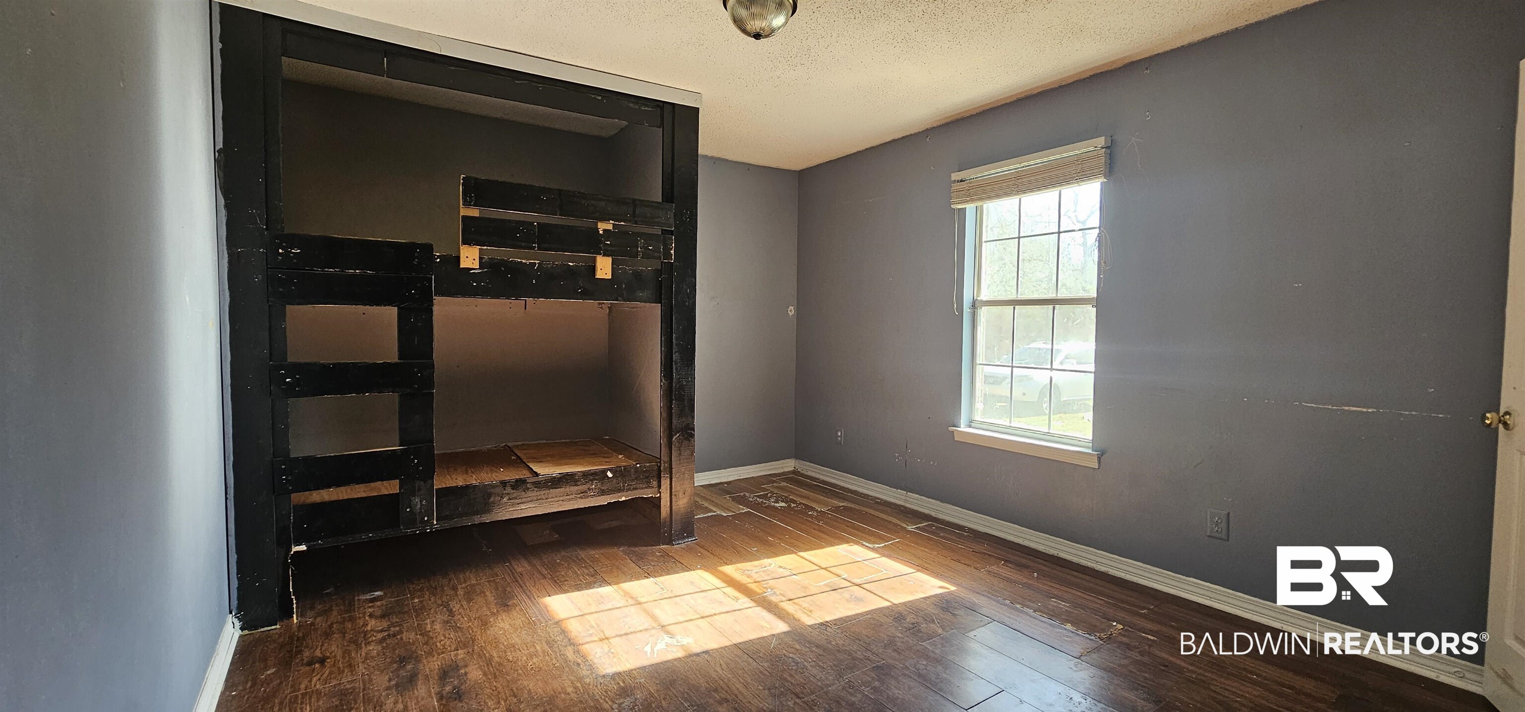 151 Bullard Street Atmore, AL 36502 - Photo 16 of 38 Unfurnished bedroom featuring hardwood / wood-style flooring and a textured ceiling