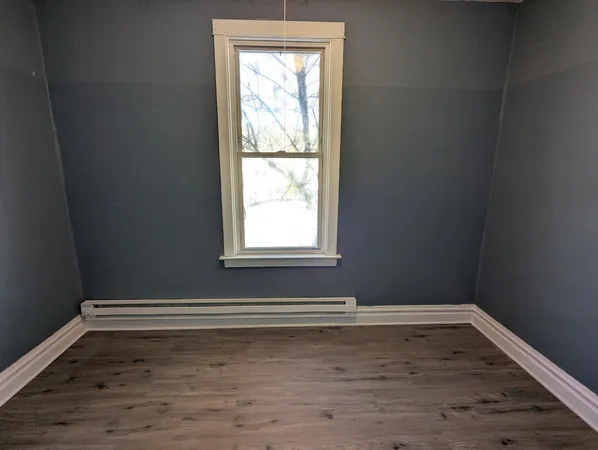 a view of a room with wooden floor and window