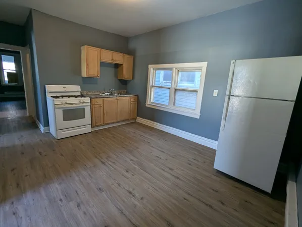 a kitchen with stainless steel appliances a refrigerator a stove a microwave and a window