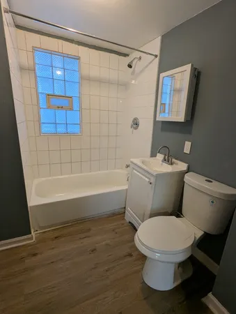 a white toilet and tub sitting next to a bathroom sink