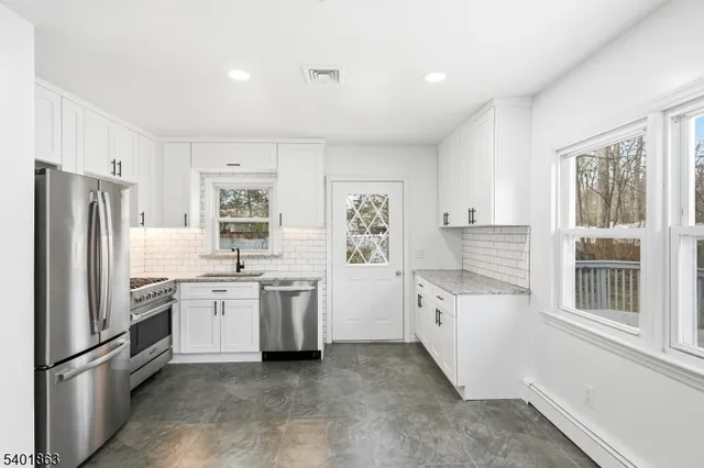 a kitchen with white cabinets and stainless steel appliances