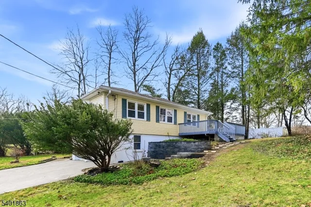 a front view of a house with a yard and large tree