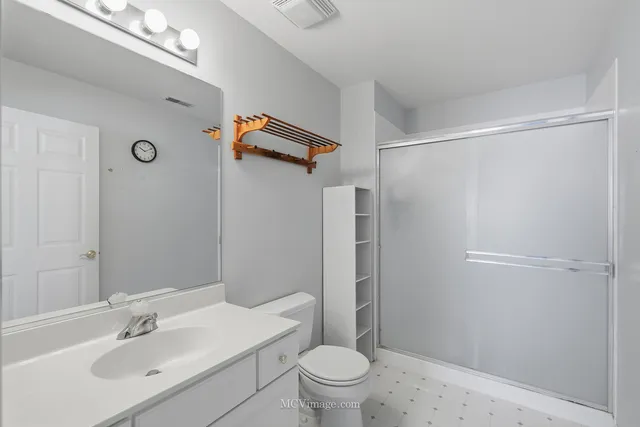 a bedroom with a bed and large windows