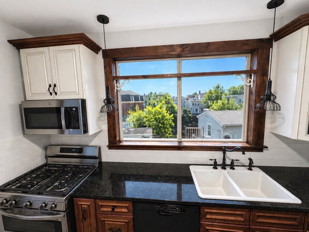 a kitchen with a stove a sink and a window