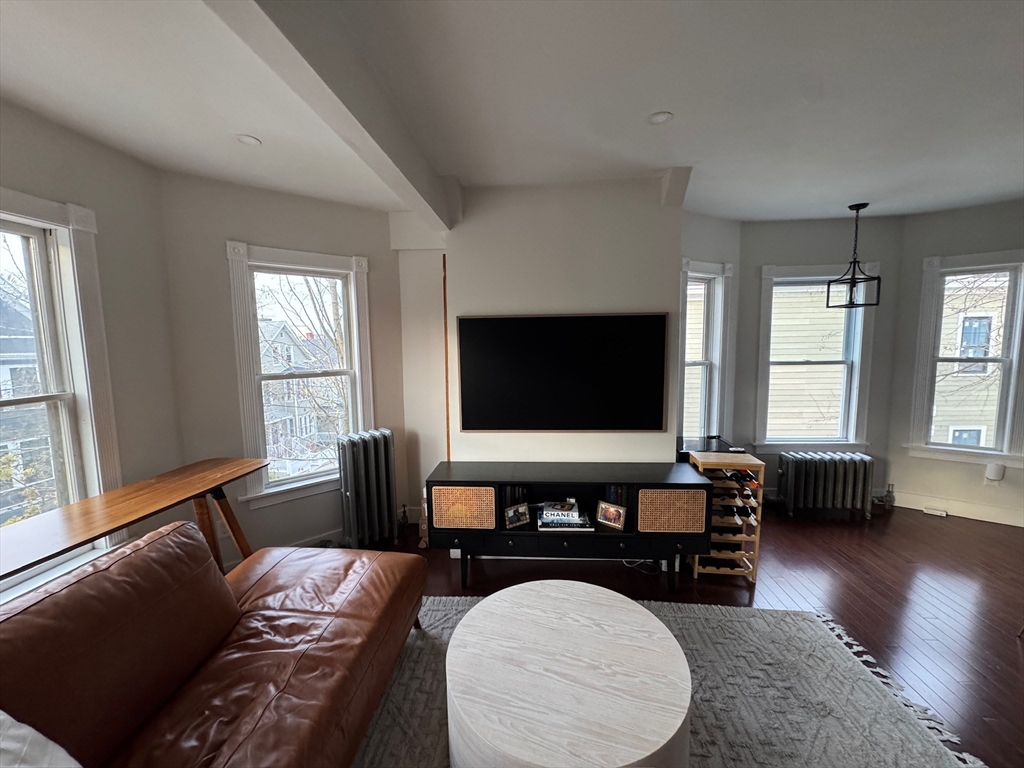 38 Pinckney Street, Unit 3 Somerville, MA 02145 - Photo 11 of 40 a living room with furniture and a flat screen tv
