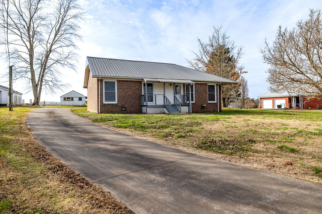 210 Salem Road Minor Hill, TN 38473 - Photo 2 of 27 a front view of a house with a garden and trees