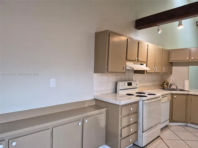 a kitchen with cabinets stainless steel appliances and a counter space