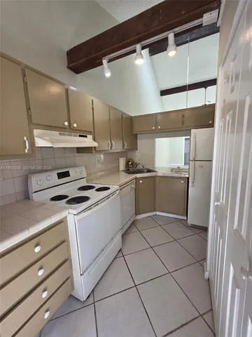 a kitchen with a stove cabinets and a refrigerator