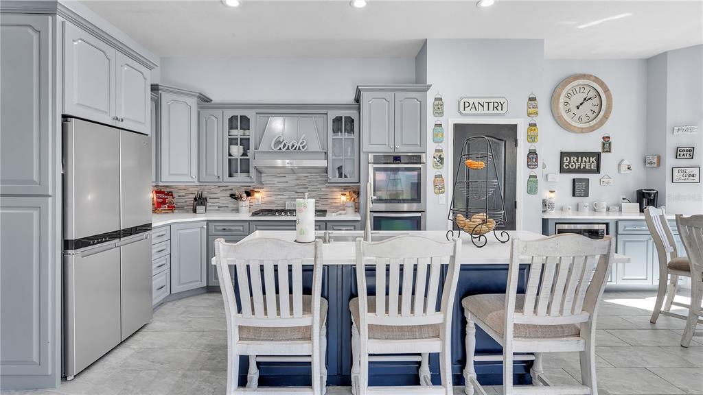 3943 West Campbell Road Lakeland, FL 33810 - Photo 12 of 71 a kitchen with stainless steel appliances granite countertop a dining table chairs refrigerator and cabinets