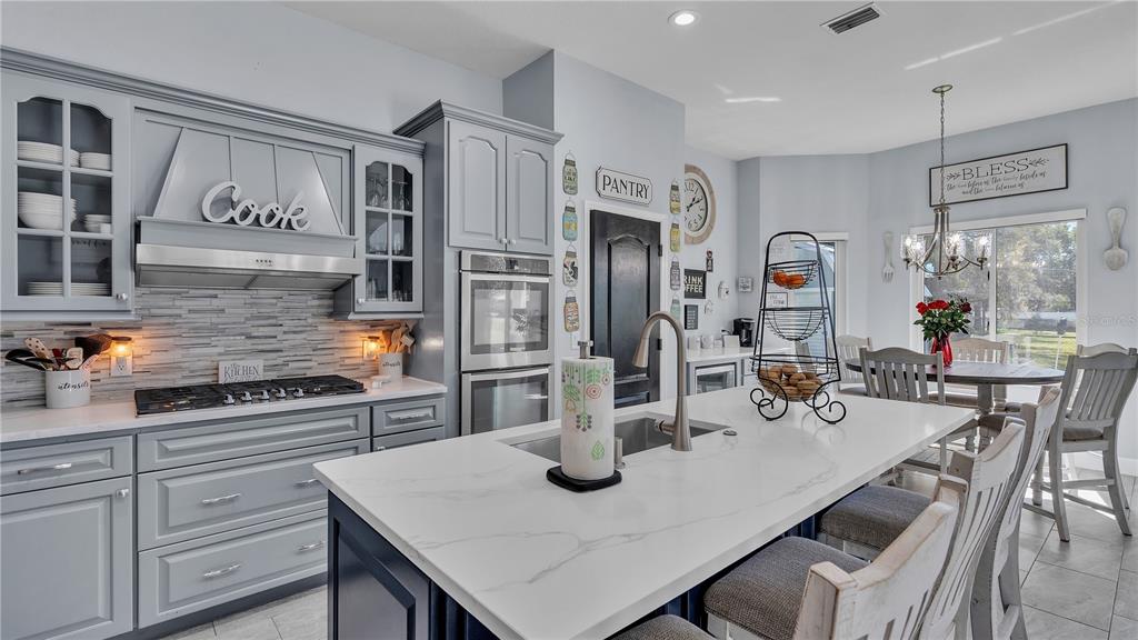 3943 West Campbell Road Lakeland, FL 33810 - Photo 17 of 71 a kitchen with stainless steel appliances kitchen island granite countertop a table chairs and a refrigerator