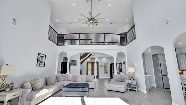 a spacious bedroom with a bed a couch and a chandelier