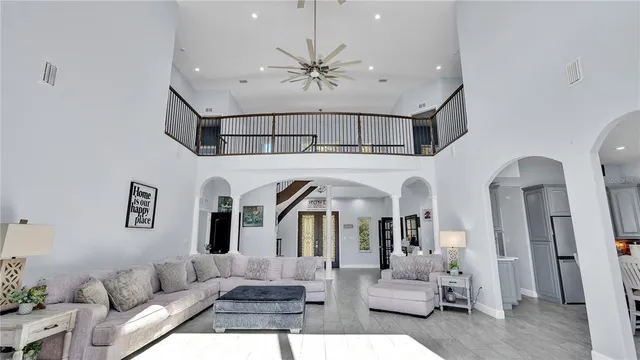 a spacious bedroom with a bed a couch and a chandelier
