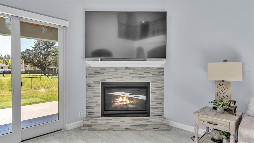 3943 West Campbell Road Lakeland, FL 33810 - Photo 22 of 71 a living room with a fireplace and a floor to ceiling window