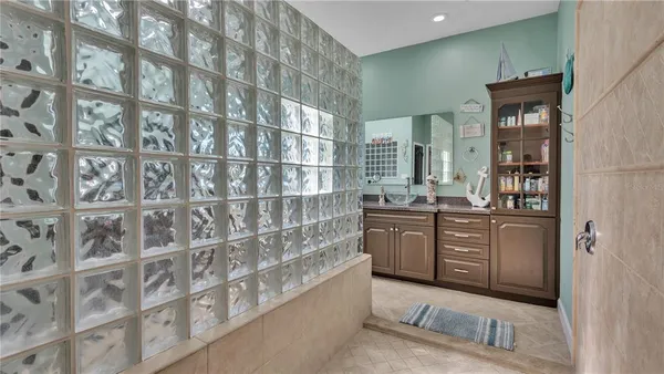 a bathroom with a granite countertop sink a toilet and a mirror