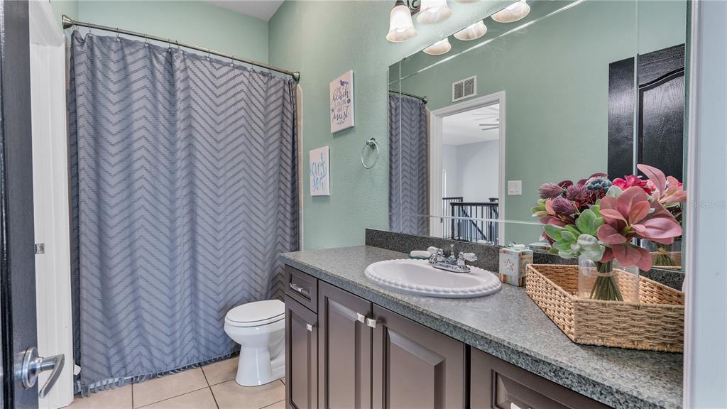 3943 West Campbell Road Lakeland, FL 33810 - Photo 49 of 71 a bathroom with a granite countertop sink a toilet and a mirror