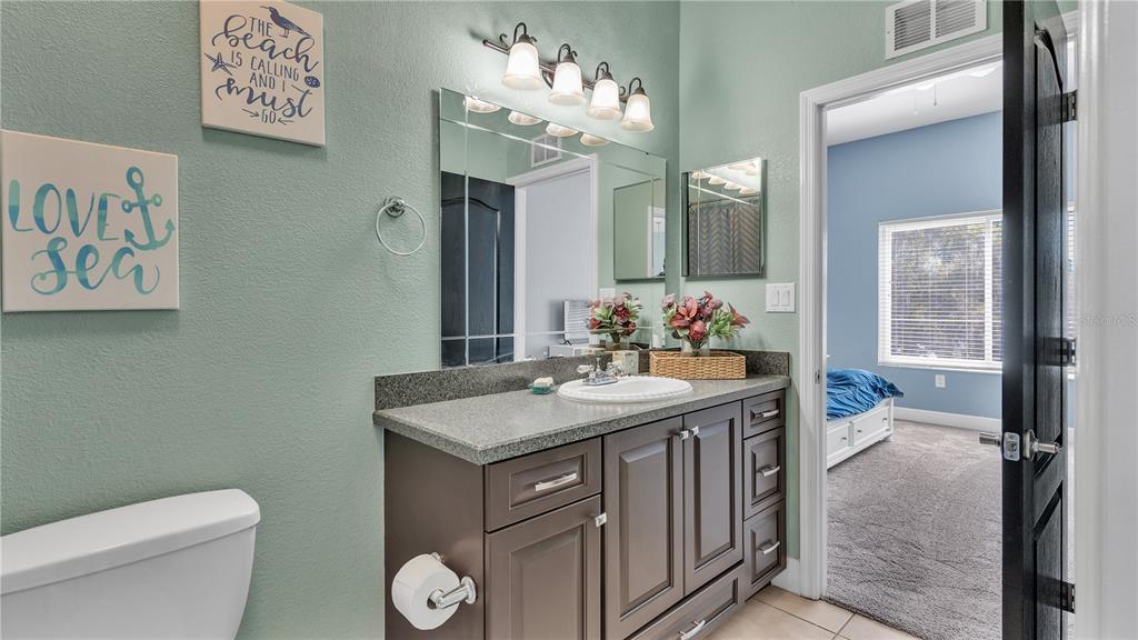 3943 West Campbell Road Lakeland, FL 33810 - Photo 50 of 71 a bathroom with a granite countertop sink a toilet and a mirror