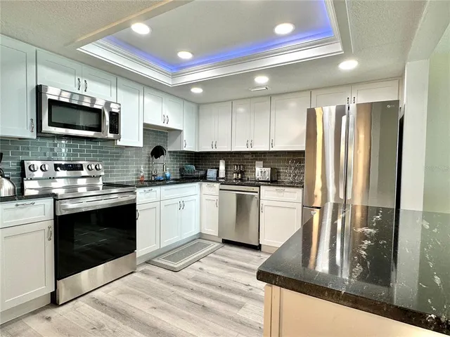 a kitchen with appliances a refrigerator and cabinets