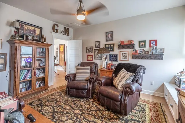 a living room with furniture a rug and bookshelf