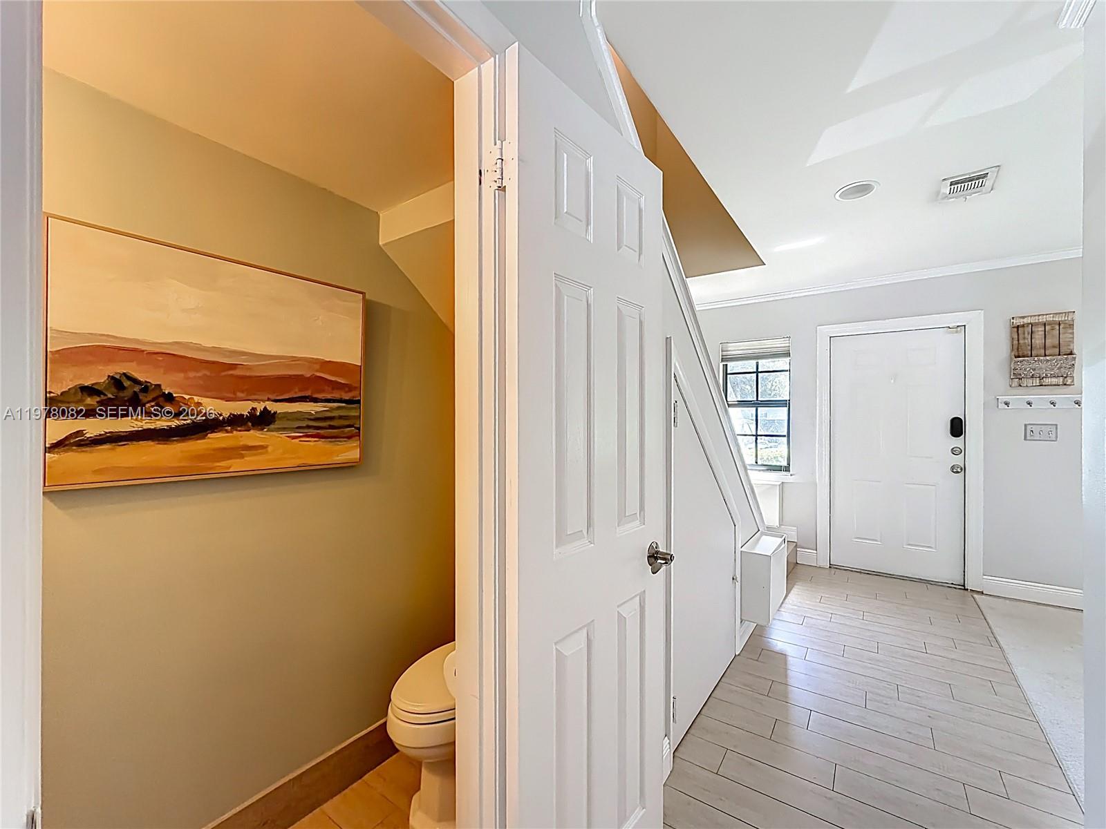 2128 Northeast 9th Avenue Wilton Manors, FL 33305 - Photo 14 of 34 a view of a hallway with wooden floor and staircase