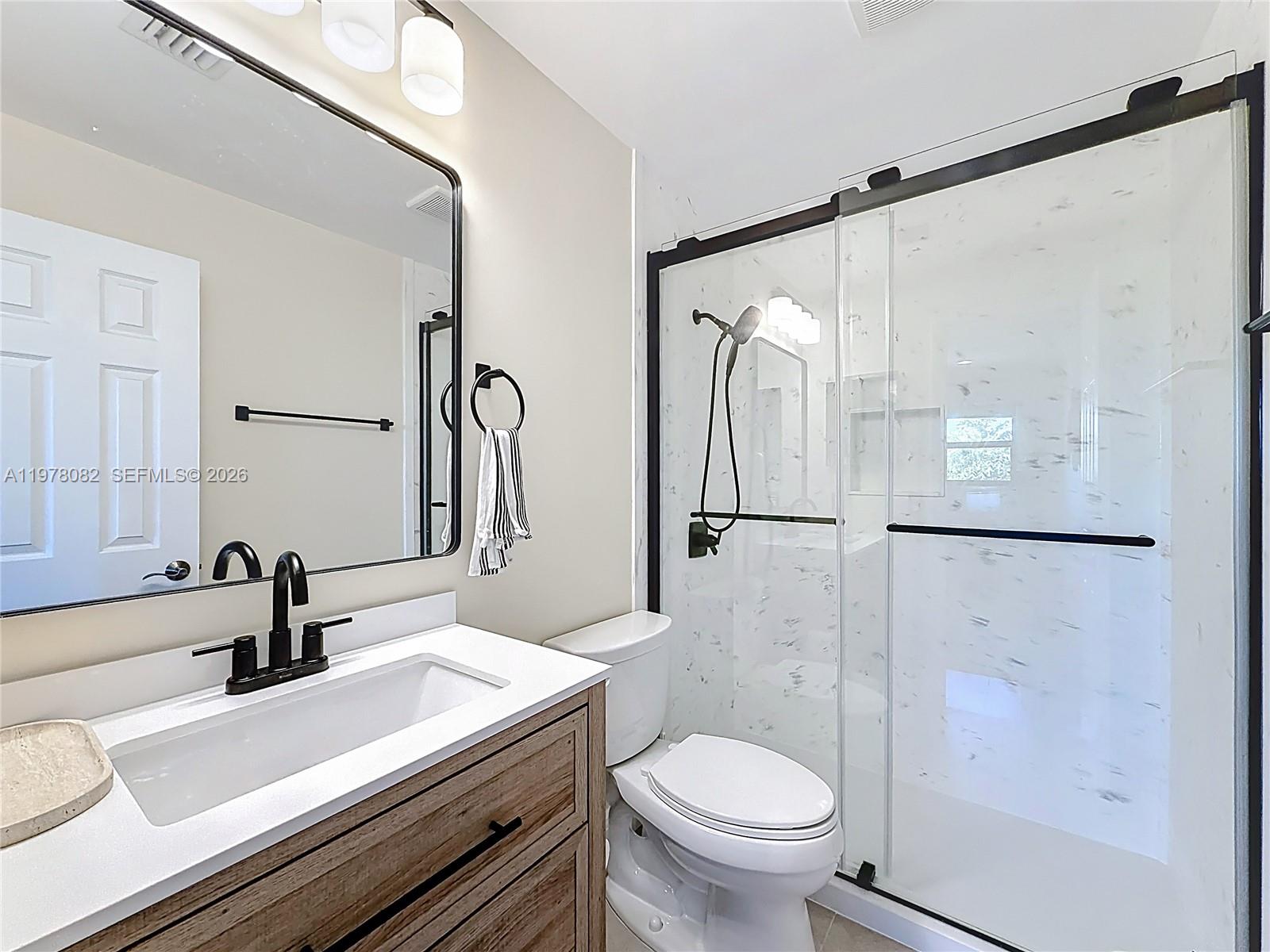 2128 Northeast 9th Avenue Wilton Manors, FL 33305 - Photo 24 of 34 a bathroom with a sink toilet and shower