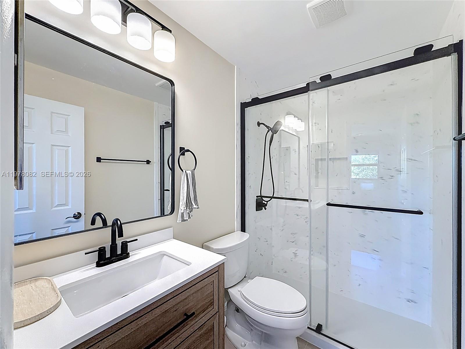 2128 Northeast 9th Avenue Wilton Manors, FL 33305 - Photo 25 of 34 a bathroom with a sink a toilet and a mirror