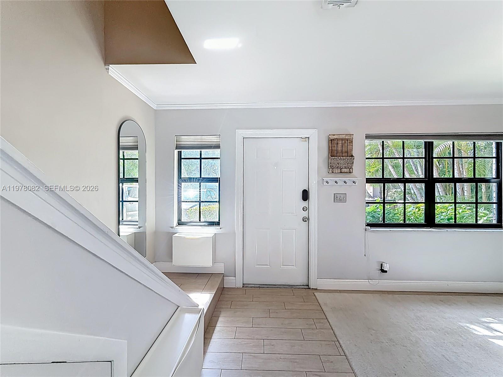 2128 Northeast 9th Avenue Wilton Manors, FL 33305 - Photo 6 of 34 a view of an entryway with wooden floor and windows