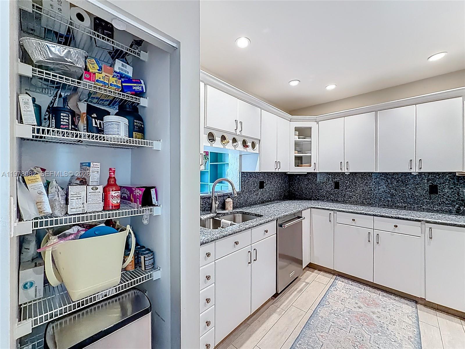 2128 Northeast 9th Avenue Wilton Manors, FL 33305 - Photo 8 of 34 a kitchen with stainless steel appliances granite countertop a sink and cabinets