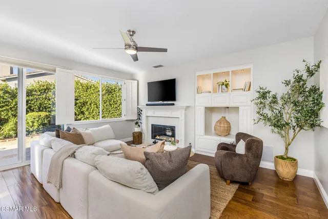 a living room with furniture a fireplace and a potted plant