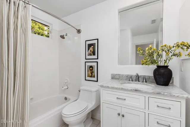 a bathroom with a granite countertop toilet sink and bathtub