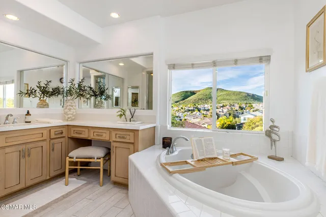 a spacious bathroom with a sink a large mirror and a bathtub