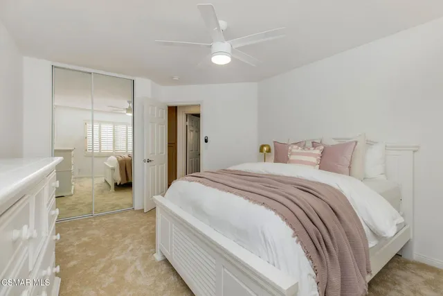 a spacious bedroom with a bed and a chandelier