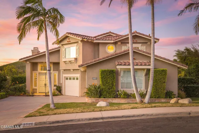 a front view of a house with a garden and plants