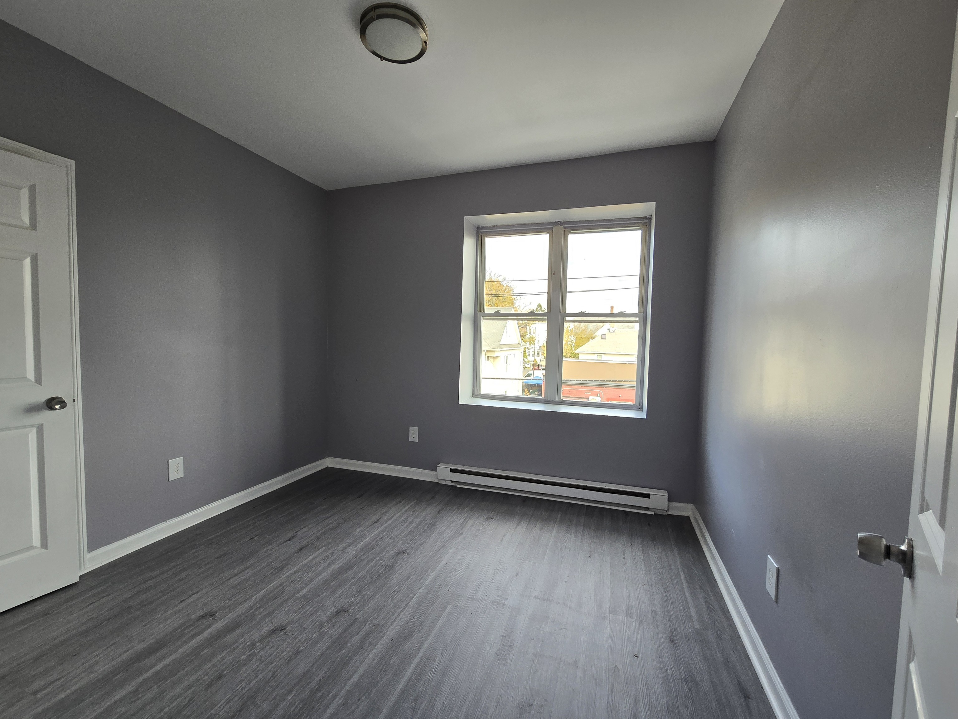 31 Whittier Street, Unit 3A Bridgeport, CT 06605 - Photo 2 of 5 an empty room with wooden floor and windows